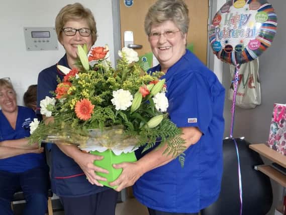 Lorraine Dickinson receiving flowers as she retired after nearly 50 years