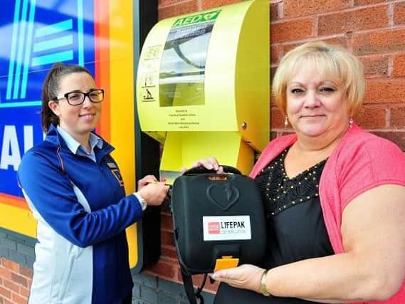 Flashback: Aldi branch manager Anna Bagguley, left, with Debbie Parkinson and the new defibrillator