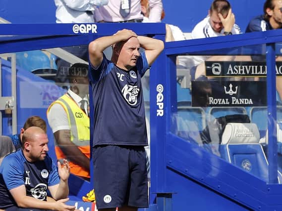 Paul Cook watches his Wigan Athletic players at QPR