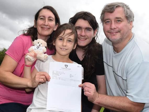 Eight-year-old Ellie Barnes celebrates gaining the top grade, nine, in her maths GCSE exam, pictured with proud family, mum Angela, brother Thomas,12, and dad Simon, right