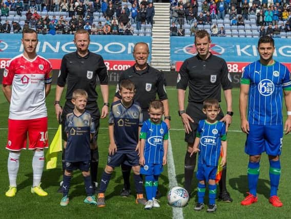 Charlie (front right) with match officials, Latics and Barnsley captains and fellow mascots