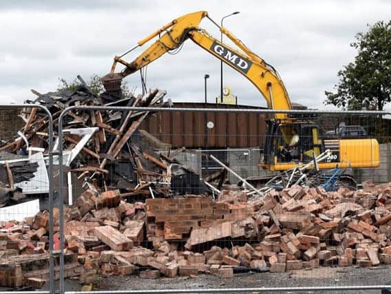 The demolition vehicle reduces the former 999 base to rubble
