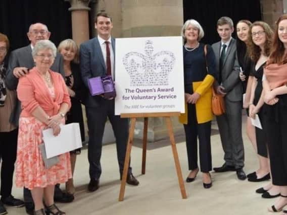 Wigan Little Theatre members celebrate their Queens Award for Voluntary Service after a ceremony at Gorton Monastery