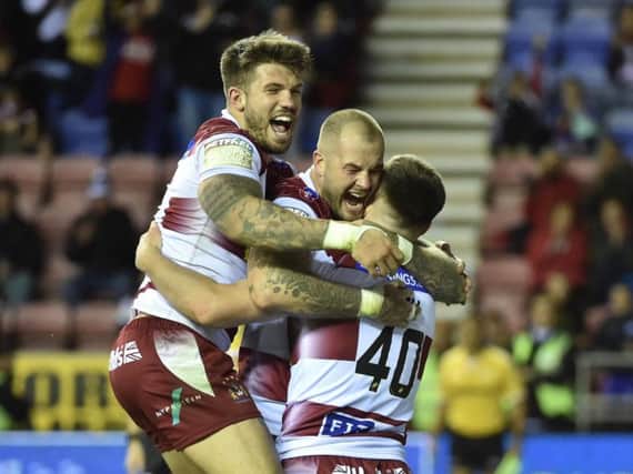 Oliver Gildart and Zak Hardaker congratulate Harry Smith after his debut try