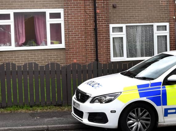 Police outside flats on Scot Lane, where a window was broken