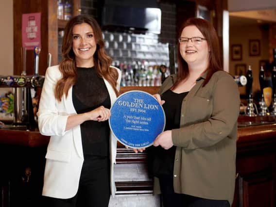 Kym Marsh presenting a personalised blue plaque to publican Georgia at The Golden Lion