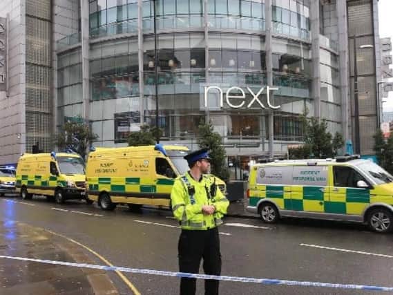 Police outside the Arndale Shopping Centre yesterday after three people were stabbed an another person injured
