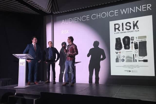 Director Luke Bradford receives the Leigh Short Film Festival overall prize for Risk. On stage with host Alexi Papadopoulos and actor Darren Jeffries