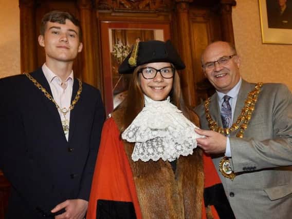Bedford High School pupil Rachel Lawrence tries on the Mayoral robes, pictured in the Mayors Parlour with the Mayor of Wigan Coun Steve Dawber and consort Oliver Waite, left