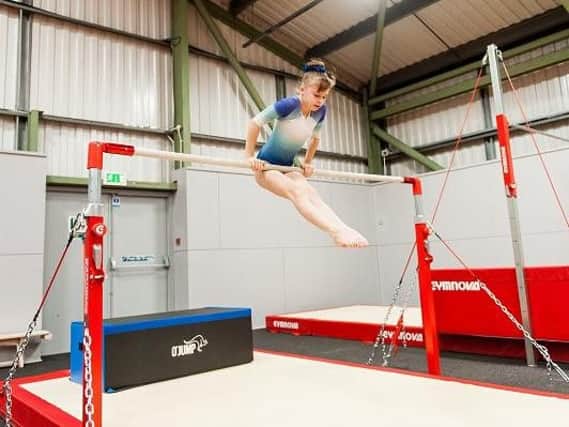 A young gymnast tries out some of the new equipment