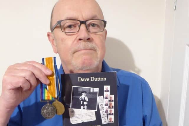 Dave Dutton with his autobiography and Herbert's medals