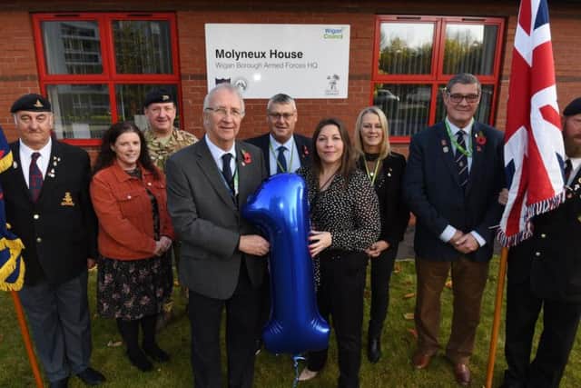 Leader of Wigan Council Coun David Molyneux, front left, with Laura Ingham managing director of Wigan Borough Armed Forces Community HQ,  front right, with veterans and members of the board, celebrate the first anniversary of the Armed Forces HQ