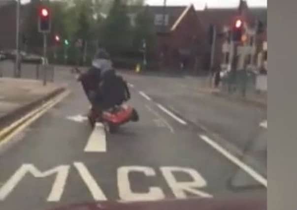 A screengrab from the footage showing the scooter doing a wheelie