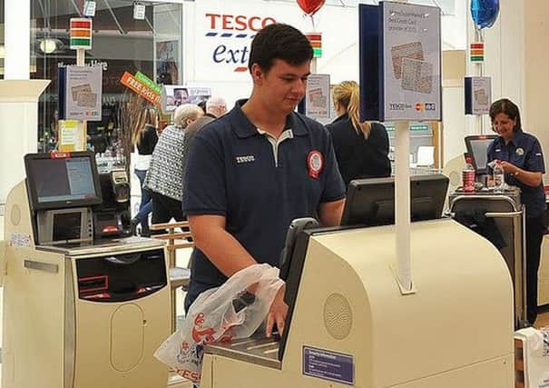 A shopper users a self-service checkout at a Tesco store. Credit: Tesco