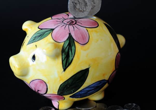 Putting coins in a piggy bank: wages may be rising as the economy picks up but parents are still putting the squeeze on pocket money . Photo: Nick Ansell/PA Wire