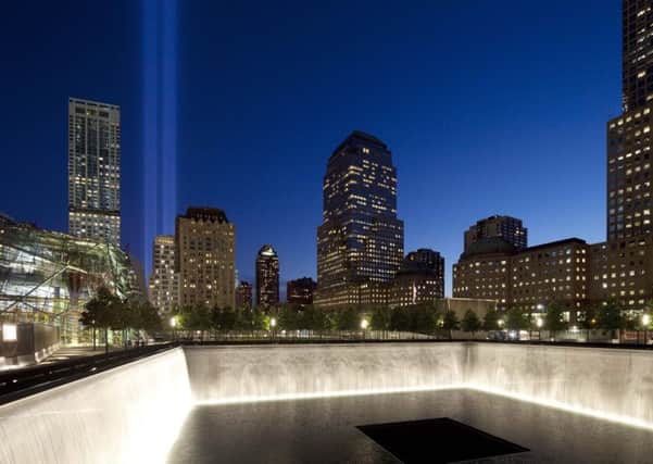 The Tribute in Light shines above a reflecting pool at the National September 11 Memorial