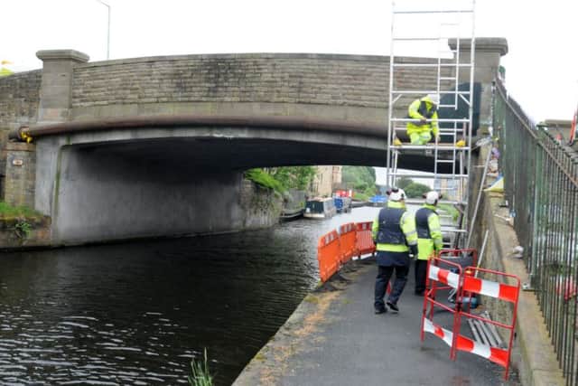 Workmen work on the bridge where Robbie Williamson fell to his death more safe.