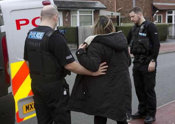 A woman is arrested during the police's Operation Oympus crackdown on domestic violence