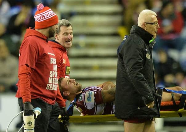 Micky McIlorum shares a joke with medics as he is stretchered off