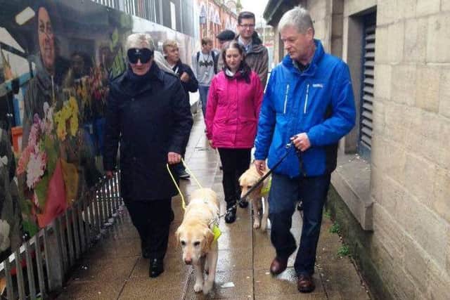 Tony Lloyd taking part in a blindfold walk in Tameside with the Guide Dogs for the Blind Association