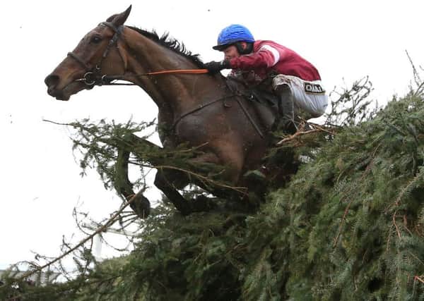Jockey David Mullins jumps the last fence on board Rule The World during the Grand National