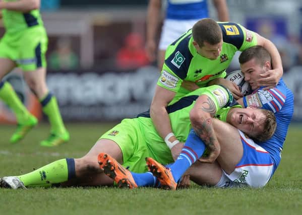 Wakefield Wildcats's Max Jowitt is tackled by Wigan Warriors' Dan Sarginson and Tony Clubb in the club's heaviest Super League defeat for a decade