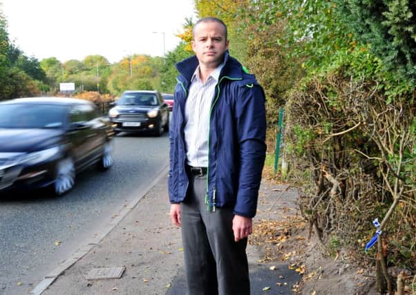 Councillor for Abram, Carl Sweeney, stands by the the place where a street lamp was removed on Bickershaw Lane, Abram, after a car crashed into it. Residents are calling for speed restrictions after several crashes on the road