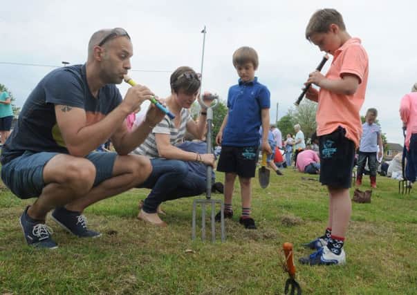 Families and friends take part in the third annual Aspull Worm Charming Championships, where teams try vibration techniques to get worms out of the ground