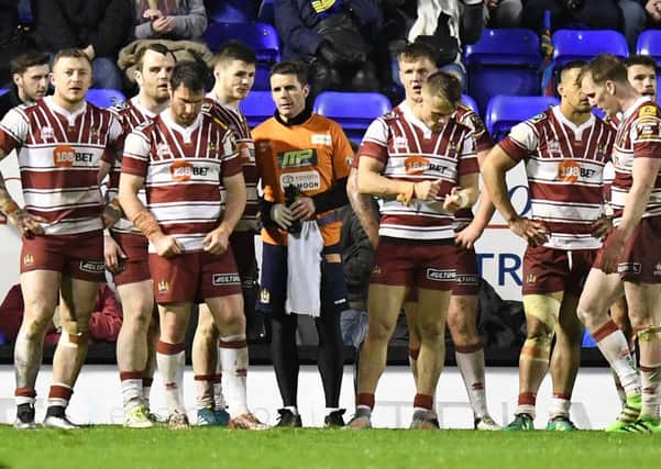 The Wigan players look dejected after conceding another try against Warrington