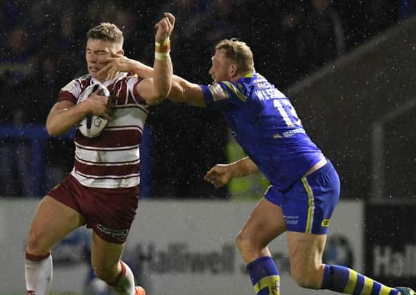 Wigan Warriors' George Williams is tackled by Warrington Wolves' Ben Westwood