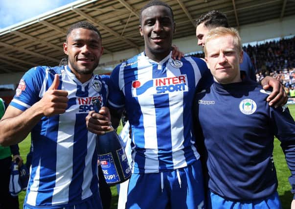 Wigan Athletic's Reece Wabara (left), Donervon Daniels (centre) and David Perkins celebrate winning promotion to the Sky Bet Championship