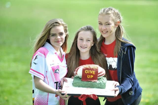 Holly McMullen (13), Kelsey Helsby (13) and Hannagh Gough (12) with a special cake

 in memory of Harrison Ledsham