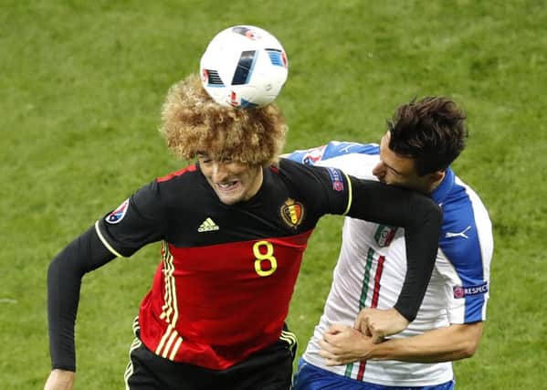 Belgium's Marouane Fellaini fights for the ball against Italy's Matteo Darmian (PA)