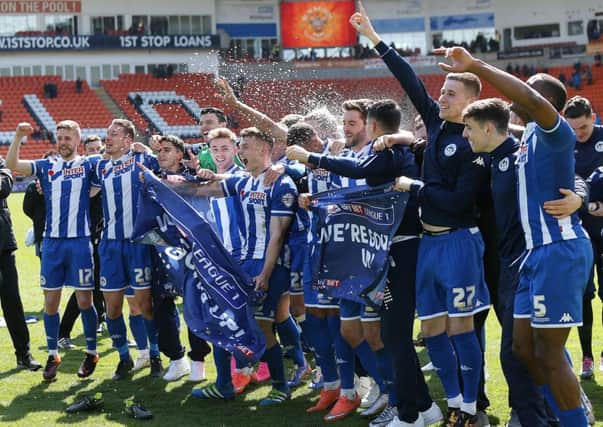 Wigan Athletic players celebrate winning promotion to the Sky Bet Championship