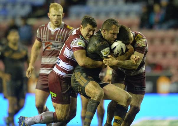 Ben Flower gets to grips with Pat Richards when Wigan met Catalans in February