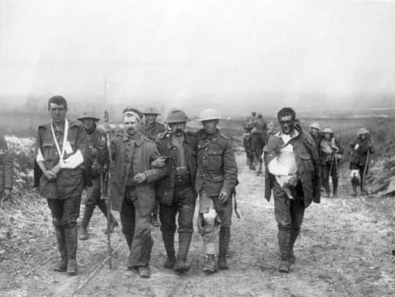A German prisoner helps wounded British soldiers back from the front near Poziers on July 19, including Private RG Wood of 8th Battalion, East Lancashire Regiment, second right