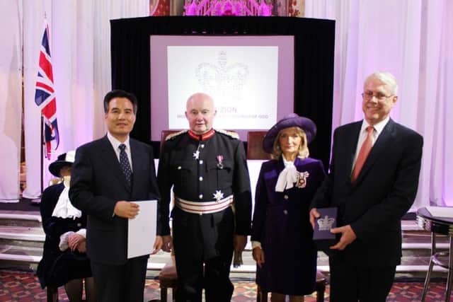 General Pastor Kim Joo-Choel and senior church leader Michael King receiving the Queen's Award from the Lord Lieutenant of Greater Manchester