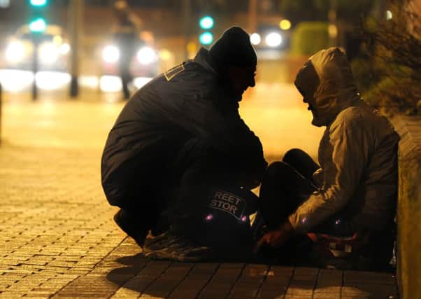 A Street Pastor helps a homeless man