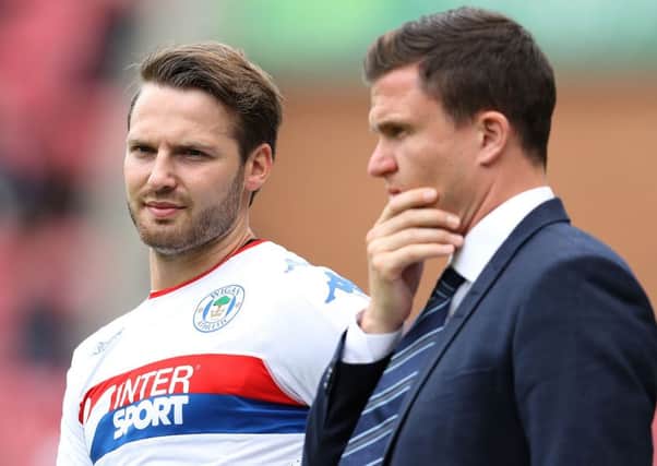 Wigan Athletic manager Gary Caldwell chats with Nick Powell