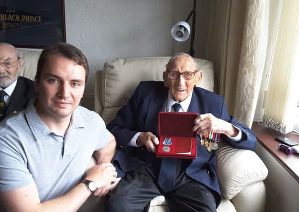 Alan Gray, from Hindley, being presented with the Ushakov Medal at his home