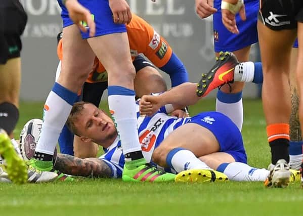Wigan Warriors' Dominic Manfredi is injured by a tackle from Rangi Chase