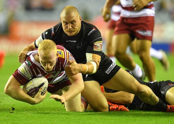 Wigan Warriors' Liam Farrell is tackled by Widnes Vikings' Gil Dudson