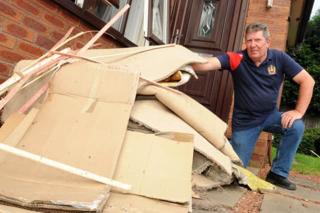 Neville Croston with some of the carpets and flooring which had to be ripped up from his son's house