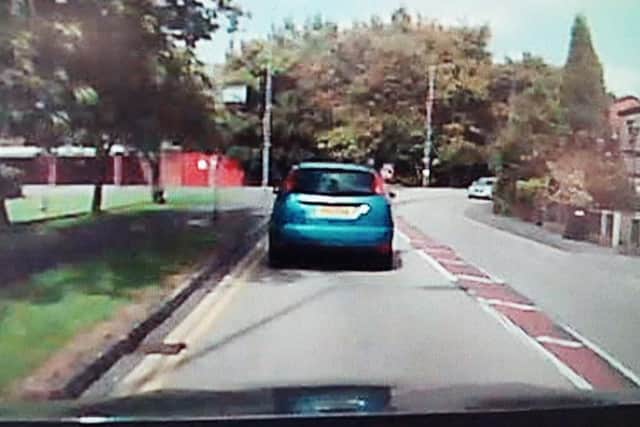 The driver sticks his head out of his car to shout abuse
