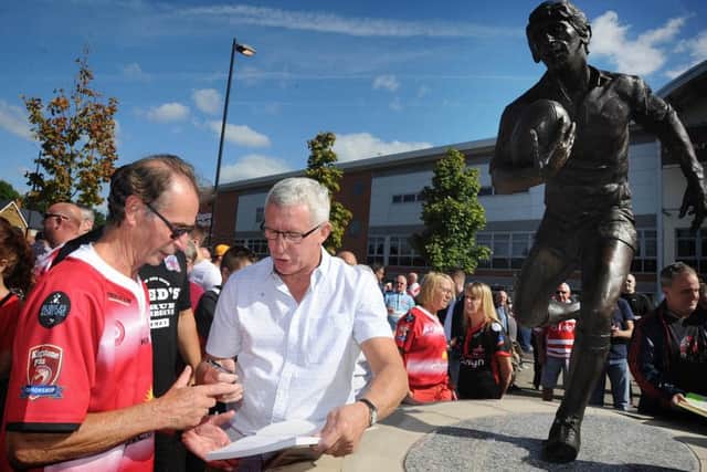 Leigh rugby league legend John Woods signing autographs next to his statue
