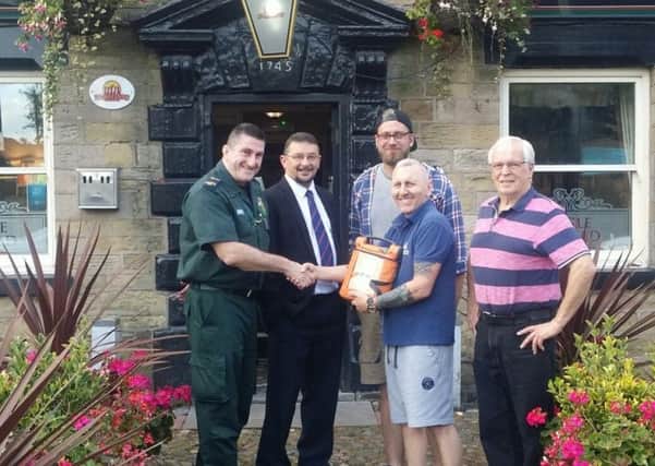 A defibrillator being presented to the Eagle and Child pub. From left: Rob Sharples from the NHS, Rob Caddock, Pete Owen, pub manager Derek Garland and Peter Peers from Billinge Football Club