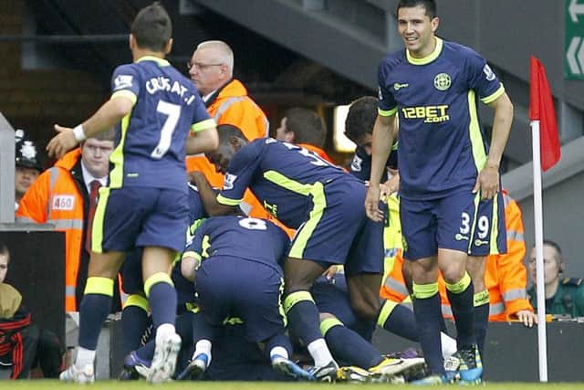 Gary Caldwell is mobbed by team-mates after scoring the winner at Anfield