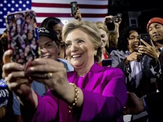 Democratic presidential candidate Hillary Clinton, left, and performer Pharrell Williams, right, greets members of the audience after speaking at a rally at Coastal Credit Union Music Park at Walnut Creek in Raleigh.