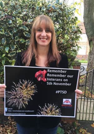 Campaigner Linda Fisher with a poster encouraging people to remember veterans when buying and setting off fireworks
