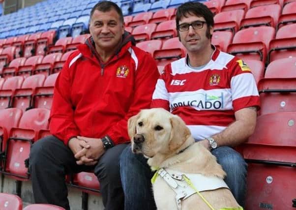 Andrew Parkinson (right) and guide dog Farley at the DW stadium in 2013